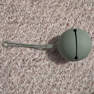 Mushie green pacifier holder